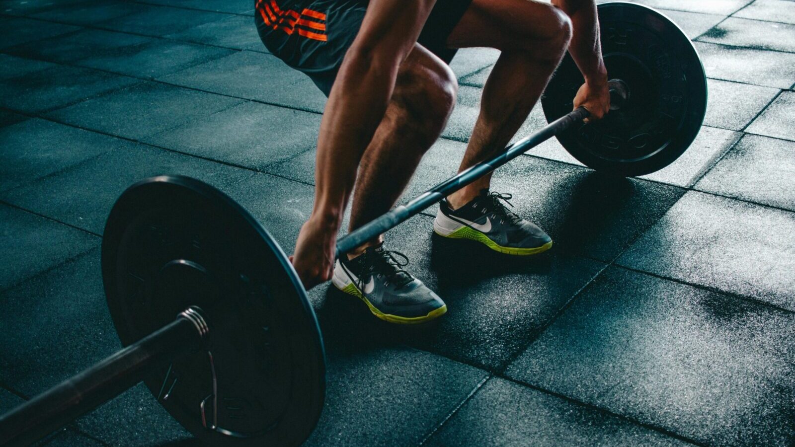 Man performing a deadlift exercise in a gym, demonstrating strength and fitness.